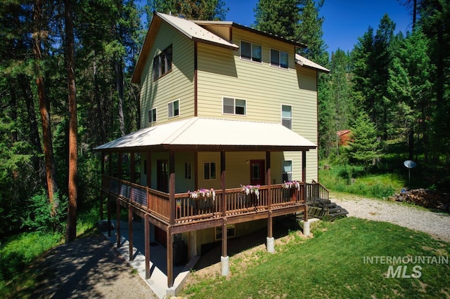 rear view of house featuring a deck and a yard