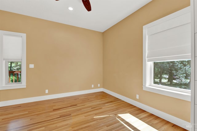 empty room with plenty of natural light, ceiling fan, and wood-type flooring
