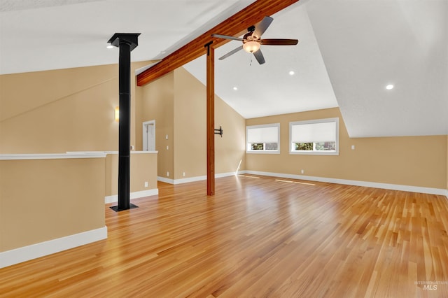 unfurnished living room with ceiling fan, lofted ceiling with beams, and light wood-type flooring