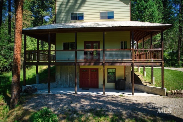 farmhouse featuring a patio area, a wooden deck, and french doors