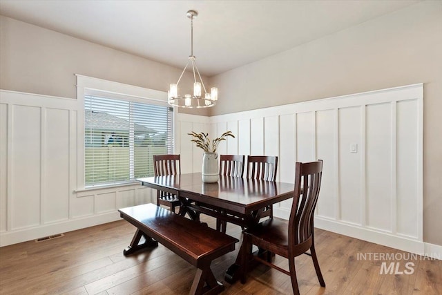 dining room with hardwood / wood-style flooring and a chandelier