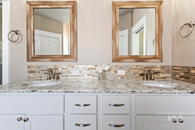 bathroom featuring vanity and decorative backsplash