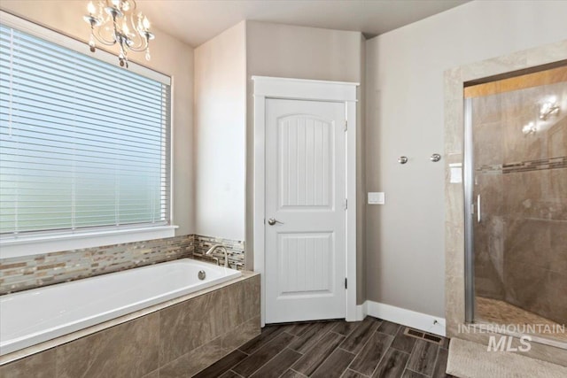 bathroom featuring a chandelier and independent shower and bath