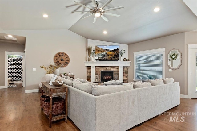 living room with lofted ceiling, a fireplace, dark wood-type flooring, and ceiling fan