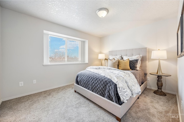 bedroom featuring a textured ceiling and light colored carpet