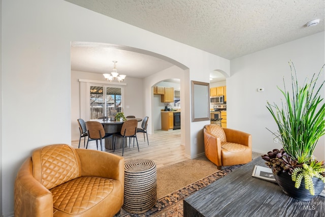 living room featuring a notable chandelier and a textured ceiling