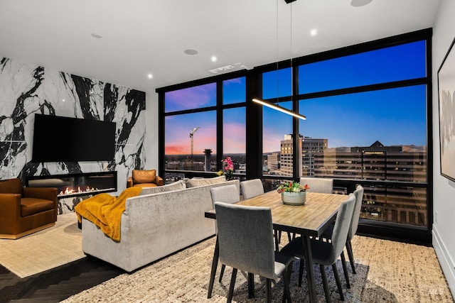 dining space featuring floor to ceiling windows and a premium fireplace