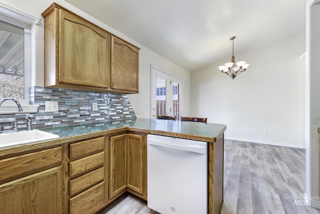 2563 Paintbrush Dr, Twin Falls, ID 83301 - kitchen with dishwasher, decorative backsplash, a peninsula, lofted ceiling, and light wood-style floors