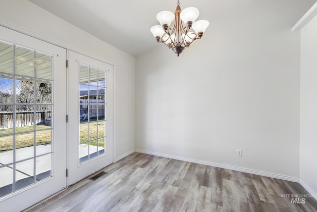 2563 Paintbrush Dr, Twin Falls, ID 83301 - unfurnished dining area featuring wood finished floors, healthy amount of natural light, a chandelier, and a water view