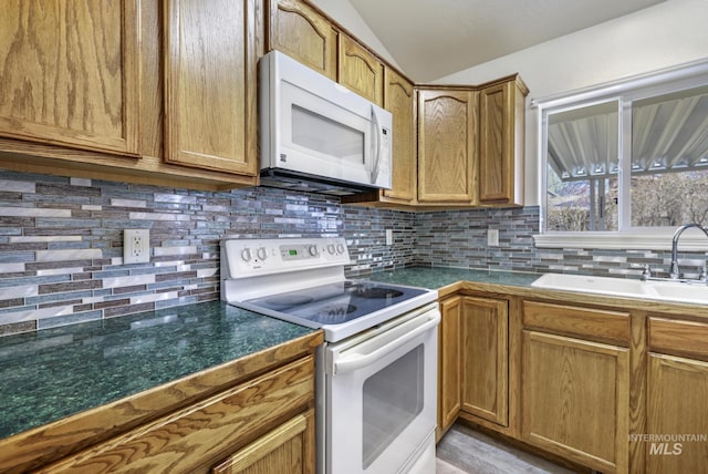 2563 Paintbrush Dr, Twin Falls, ID 83301 - kitchen featuring white appliances, lofted ceiling, tasteful backsplash, brown cabinets, and dark countertops