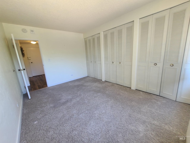 200 N 3rd Unit 401, Boise, ID 83702 - unfurnished bedroom featuring two closets, carpet, baseboards, and a textured ceiling