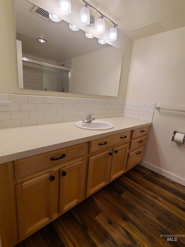 200 N 3rd Unit 401, Boise, ID 83702 - bathroom with a stall shower, vanity, tasteful backsplash, wood finished floors, and baseboards