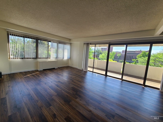 200 N 3rd Unit 401, Boise, ID 83702 - unfurnished room with a textured ceiling, dark wood-style floors, baseboards, and radiator