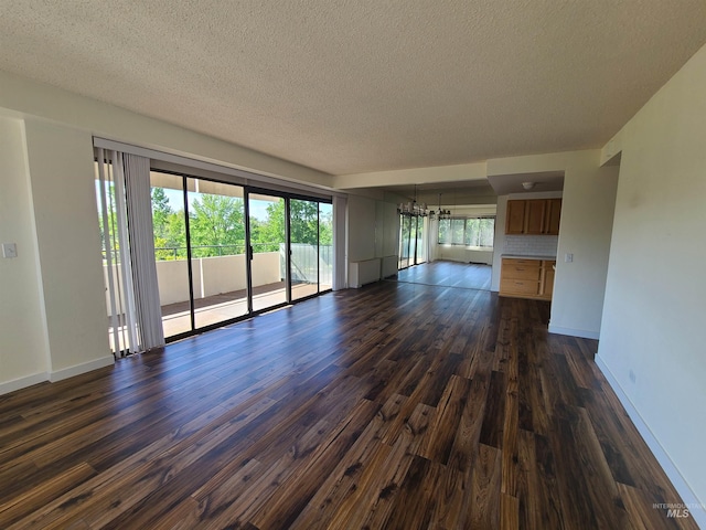 200 N 3rd Unit 401, Boise, ID 83702 - unfurnished living room with a chandelier, dark wood-style flooring, a textured ceiling, and baseboards