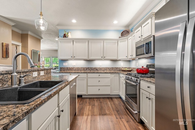 998 E Shadow Creek Ln, Eagle, ID 83616 - kitchen featuring appliances with stainless steel finishes, a sink, crown molding, dark wood-style flooring, and white cabinetry