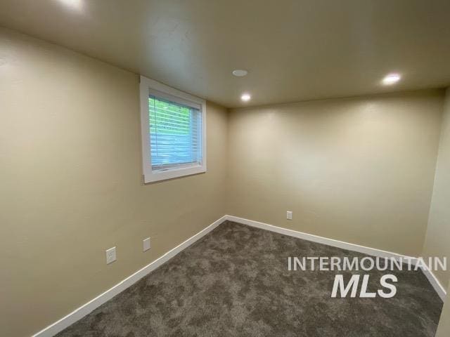 unfurnished room with dark colored carpet, baseboards, and recessed lighting