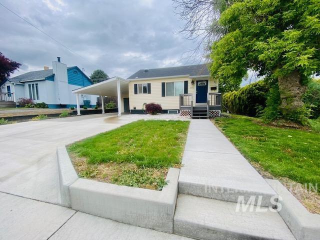 view of front of house featuring a carport, driveway, and a front yard