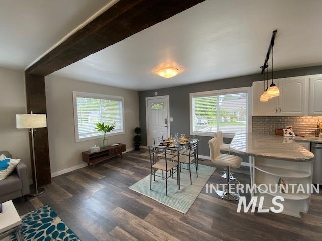 dining space featuring plenty of natural light, dark wood finished floors, and baseboards
