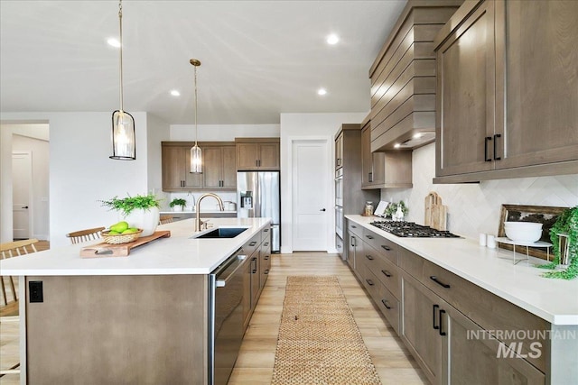 6356 S Cubola Way, Meridian, ID 83642 - kitchen featuring a sink, appliances with stainless steel finishes, decorative backsplash, light wood-type flooring, and light countertops