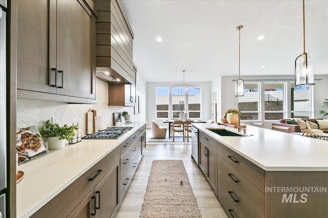 6356 S Cubola Way, Meridian, ID 83642 - kitchen with a sink, stainless steel appliances, decorative backsplash, light countertops, and a center island with sink