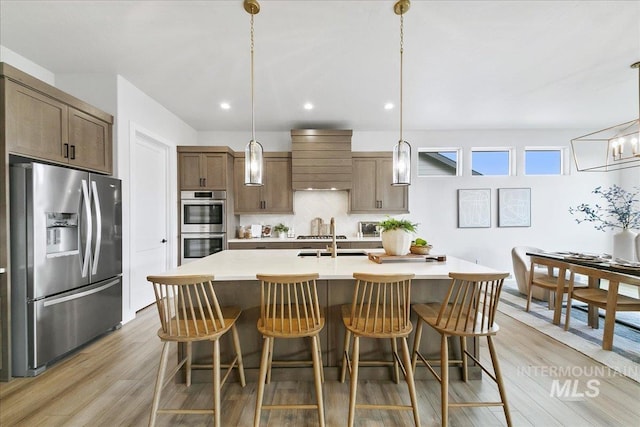 6356 S Cubola Way, Meridian, ID 83642 - kitchen featuring appliances with stainless steel finishes, backsplash, light countertops, light wood-style flooring, and recessed lighting
