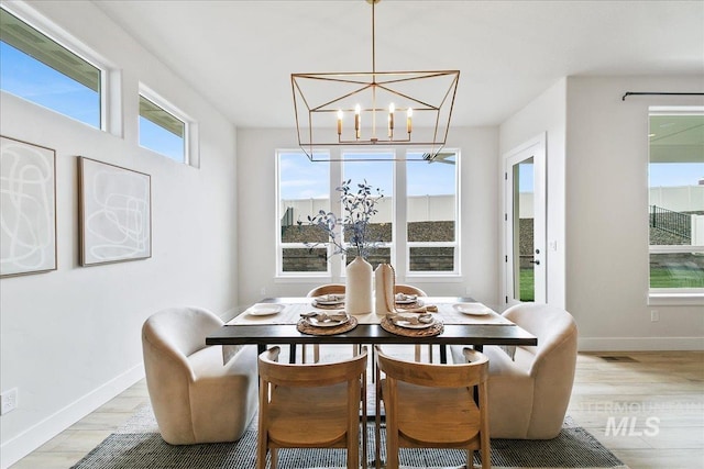 6356 S Cubola Way, Meridian, ID 83642 - dining area with light wood-style flooring, healthy amount of natural light, a chandelier, and baseboards