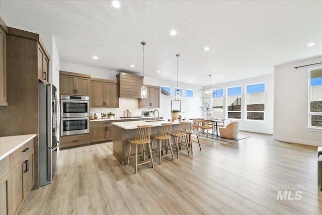 6356 S Cubola Way, Meridian, ID 83642 - kitchen with stainless steel appliances, a sink, a breakfast bar, recessed lighting, and light countertops