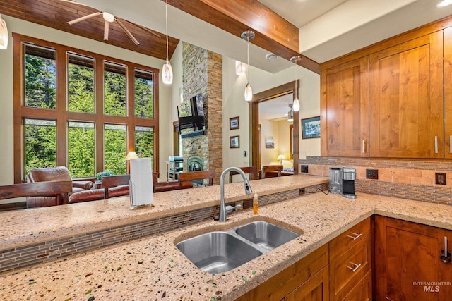 278 Elk Lake Rd, New Meadows, ID 83654 - kitchen featuring brown cabinets, light stone counters, plenty of natural light, and beamed ceiling