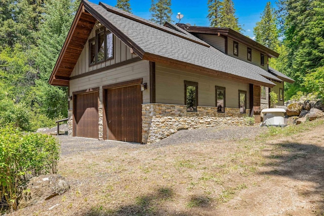 278 Elk Lake Rd, New Meadows, ID 83654 - view of home's exterior with roof with shingles, stone siding, board and batten siding, and dirt driveway
