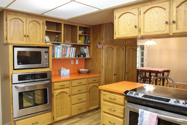 kitchen featuring appliances with stainless steel finishes and light hardwood / wood-style flooring