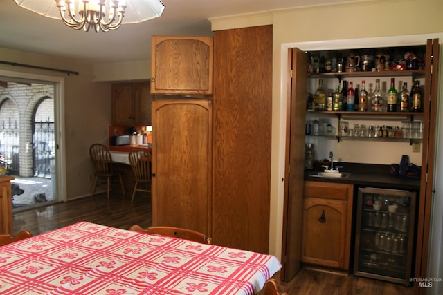 bedroom featuring wet bar, beverage cooler, an inviting chandelier, and dark hardwood / wood-style floors