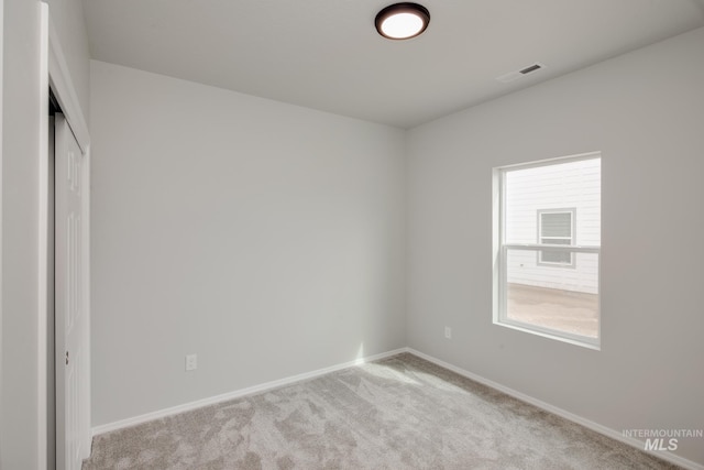 unfurnished bedroom with baseboards, visible vents, a closet, and light colored carpet