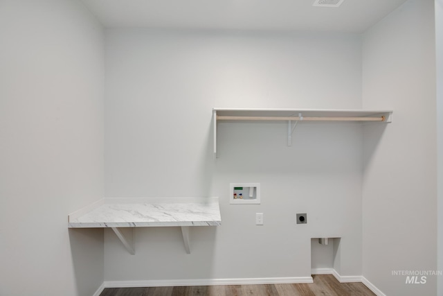 laundry area with hookup for an electric dryer, laundry area, washer hookup, wood finished floors, and baseboards