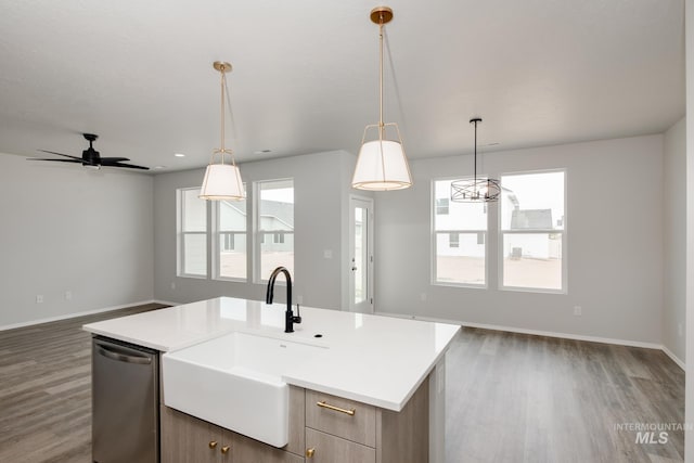 kitchen with a sink, open floor plan, light countertops, stainless steel dishwasher, and a center island with sink