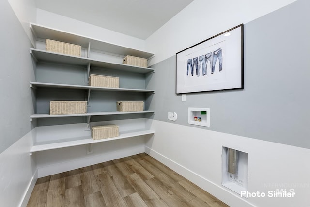 washroom with wood-type flooring and hookup for a washing machine