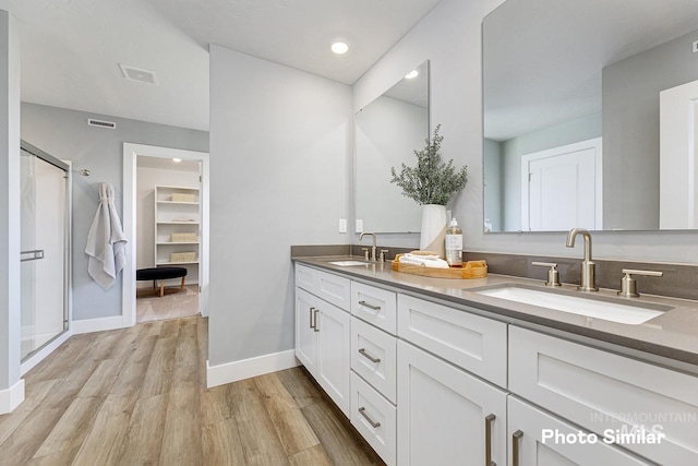 bathroom with vanity, wood-type flooring, and a shower with door