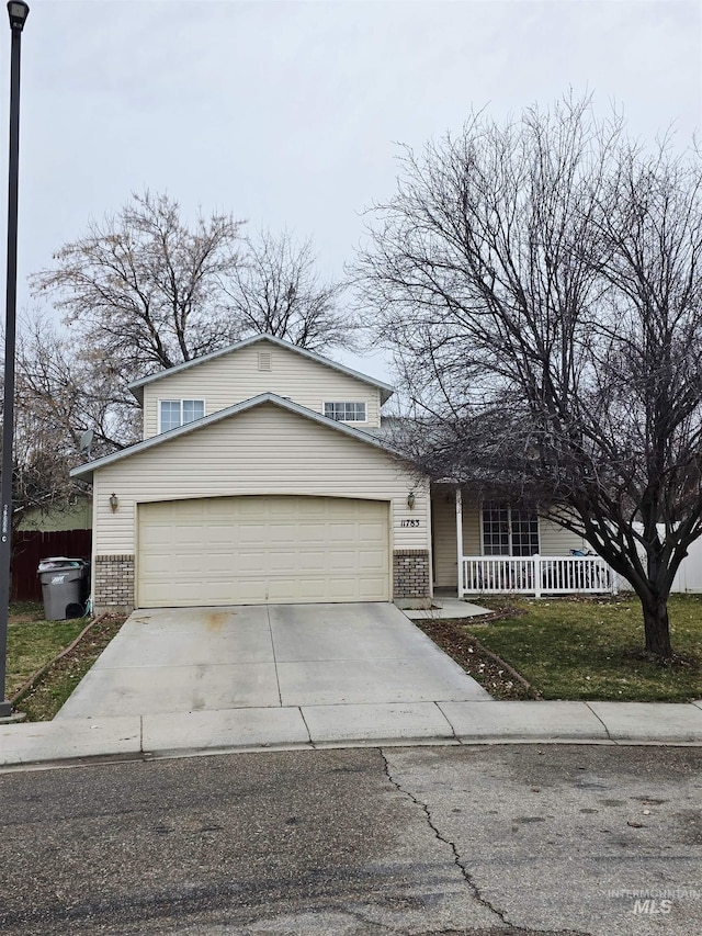 view of front of property featuring an attached garage, brick siding, a porch, and driveway