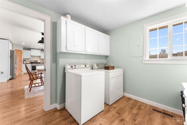 clothes washing area with separate washer and dryer, light wood-style floors, baseboards, cabinet space, and recessed lighting