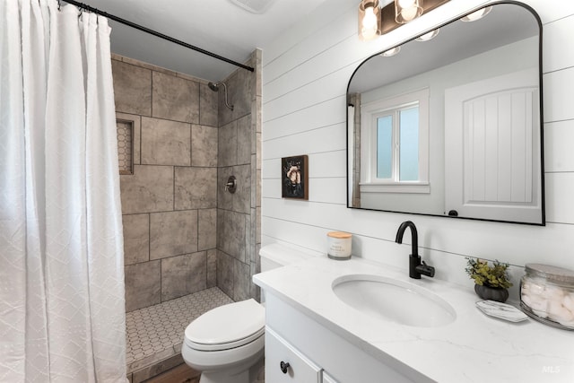 bathroom with a shower stall, toilet, and vanity