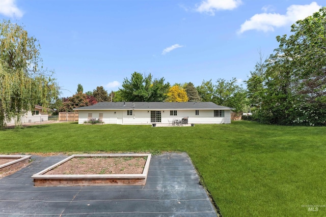 rear view of house with a vegetable garden and a patio area