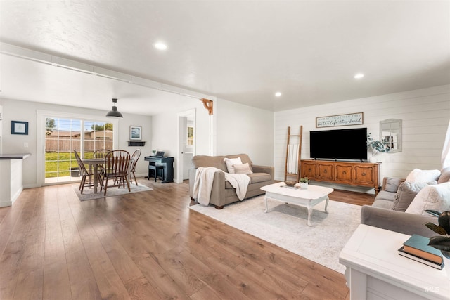 living room with wood finished floors, recessed lighting, and baseboards