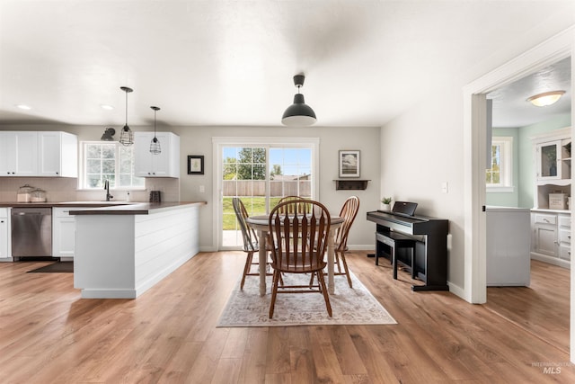 dining area with baseboards, light wood-style flooring, and recessed lighting