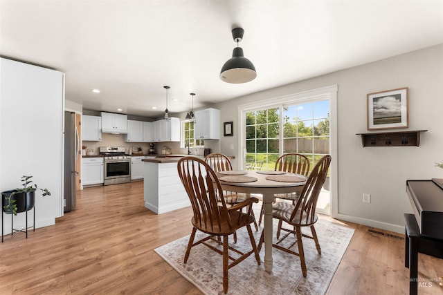 dining area with light wood finished floors, recessed lighting, and baseboards