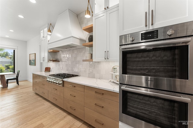 2664 N Yount Way, Eagle, ID 83616 - kitchen with open shelves, premium range hood, appliances with stainless steel finishes, light wood-style flooring, and recessed lighting