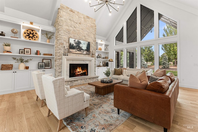 2664 N Yount Way, Eagle, ID 83616 - living room featuring light wood-style floors, a fireplace, built in shelves, high vaulted ceiling, and a chandelier