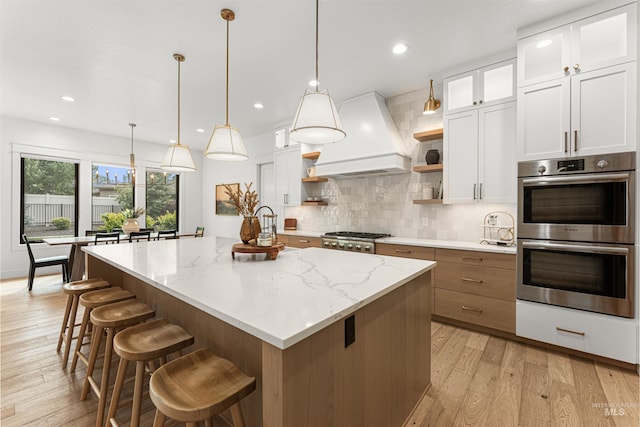 2664 N Yount Way, Eagle, ID 83616 - kitchen featuring double oven, open shelves, premium range hood, backsplash, and a kitchen island