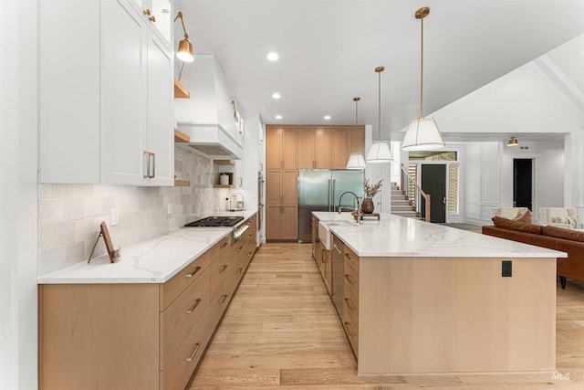2664 N Yount Way, Eagle, ID 83616 - kitchen with open shelves, custom exhaust hood, light wood-style flooring, stainless steel appliances, and decorative backsplash