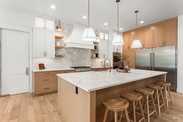 2664 N Yount Way, Eagle, ID 83616 - kitchen featuring open shelves, appliances with stainless steel finishes, custom range hood, a sink, and light wood finished floors
