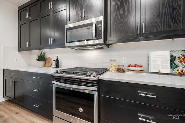 kitchen with dark cabinetry, stainless steel appliances, and light countertops