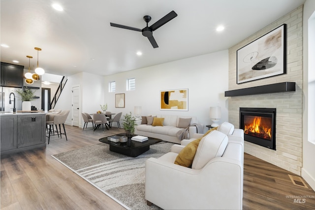 living area featuring recessed lighting, visible vents, wood finished floors, and a fireplace